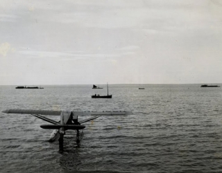 Star Air Service's Pacemaker NC168N in foreground - Alaska fishing boats in background.  Plane was wrecked in 1946 and recoved and is on display at the Alaska aviation Heritage Museum. - 965